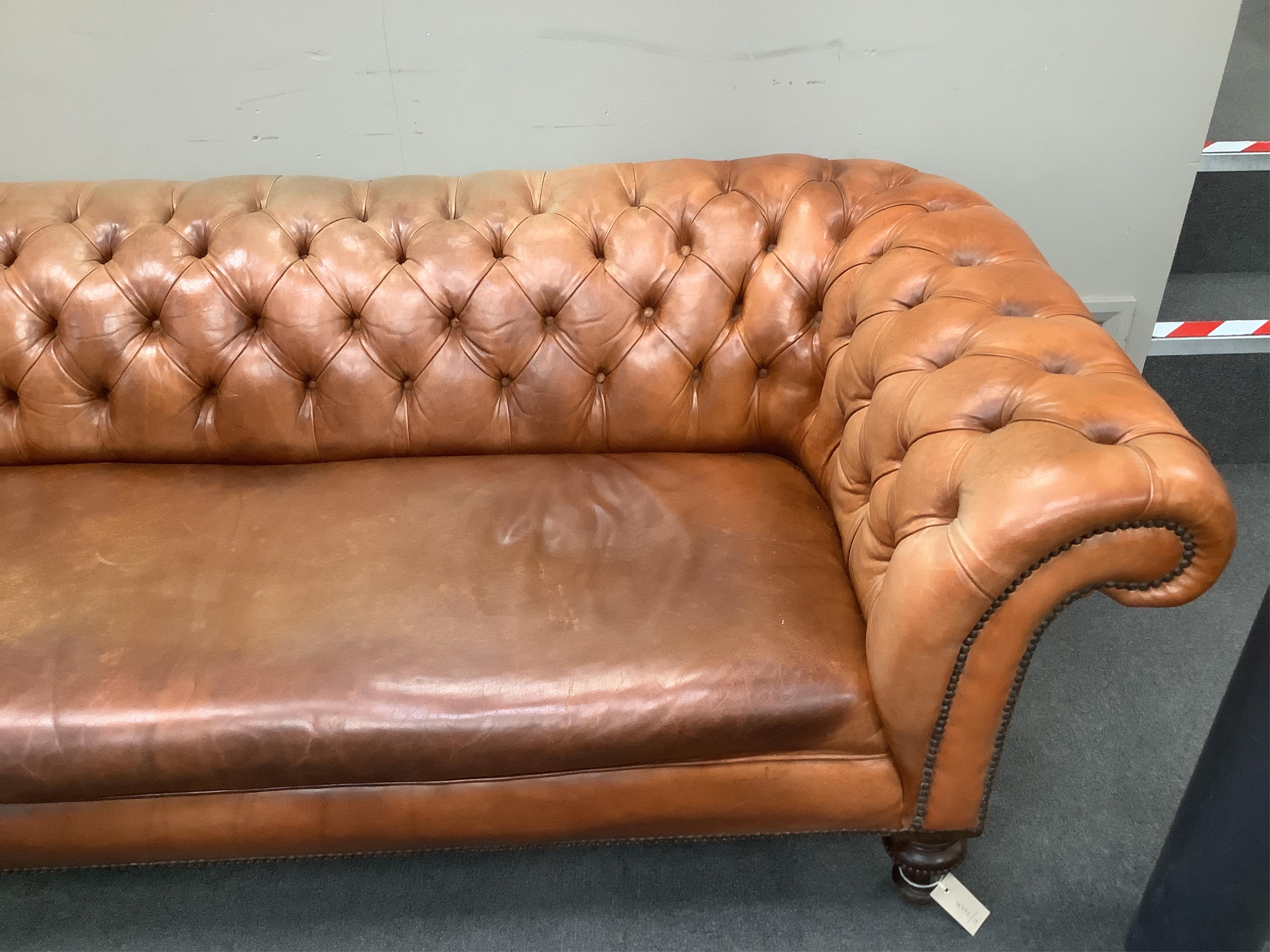 A Victorian chesterfield settee upholstered in hand dyed deep buttoned tan leather, on turned fluted feet, width 210cm, depth 92cm, height 65cm. Condition - good